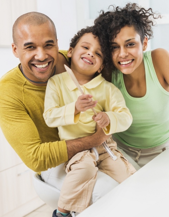 Family of three smiling in dental office