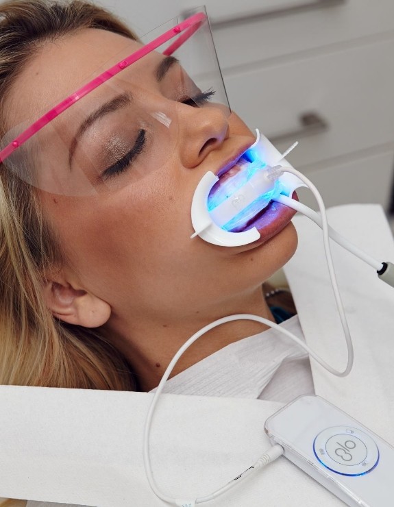 Woman getting Glo teeth whitening in dental chair
