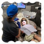 Dental team member laughing with patient in treatment chair