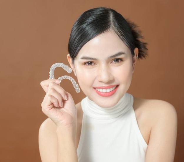 Smiling lady shows off clear aligners