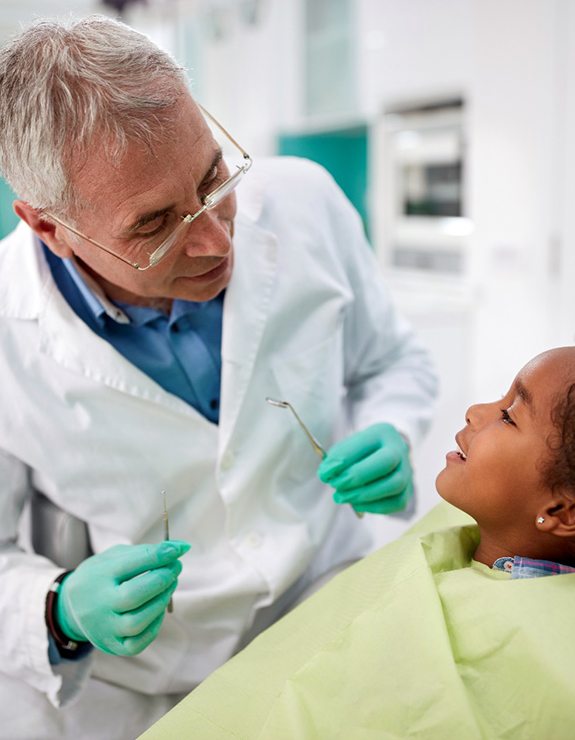 child smiling while visiting dentist 