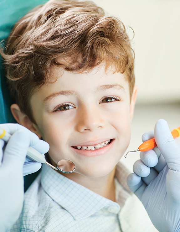 child smiling while visiting dentist 